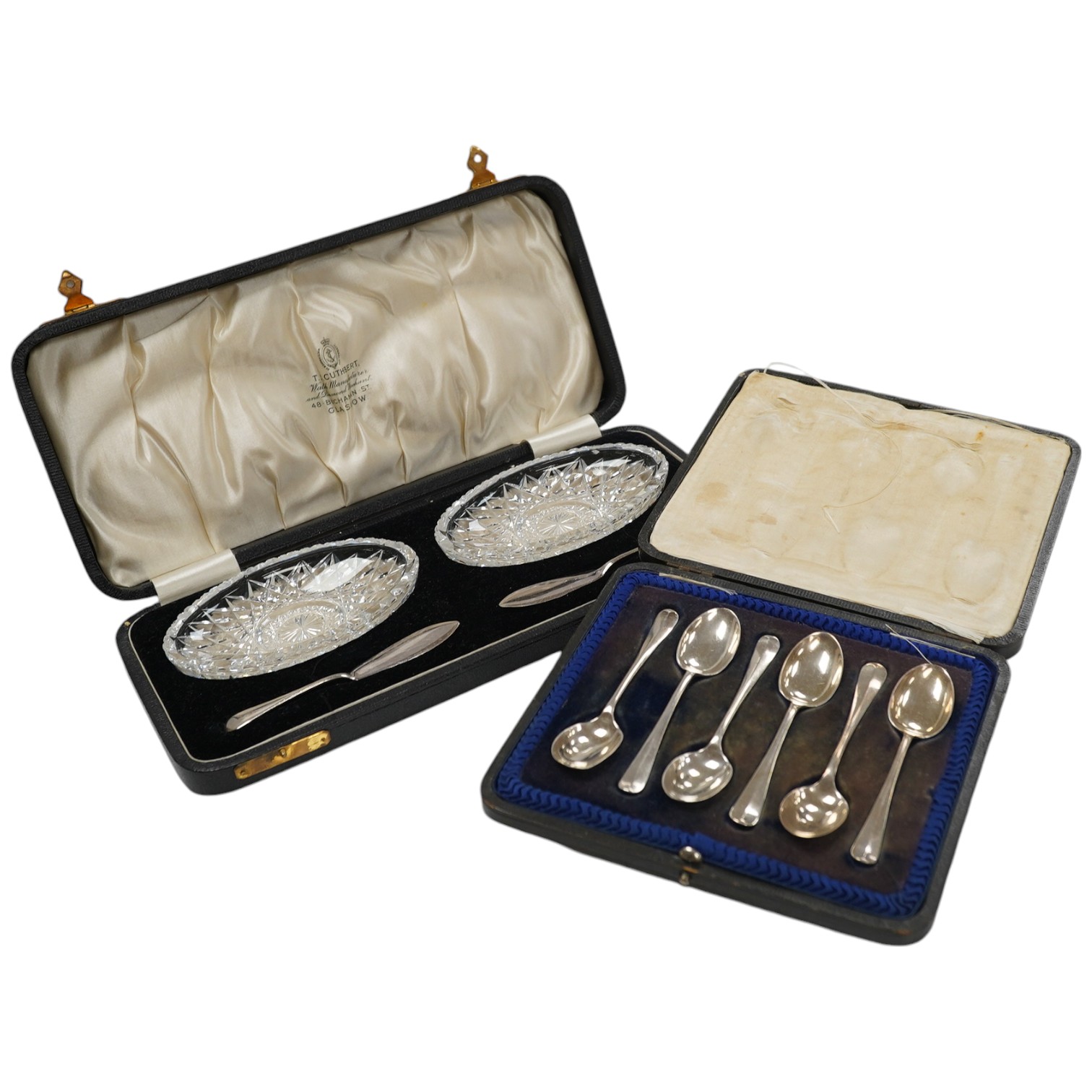 A cased set of six George V silver teaspoons and a cased pair of glass butter dishes with two silver butter knives. Condition - fair to good